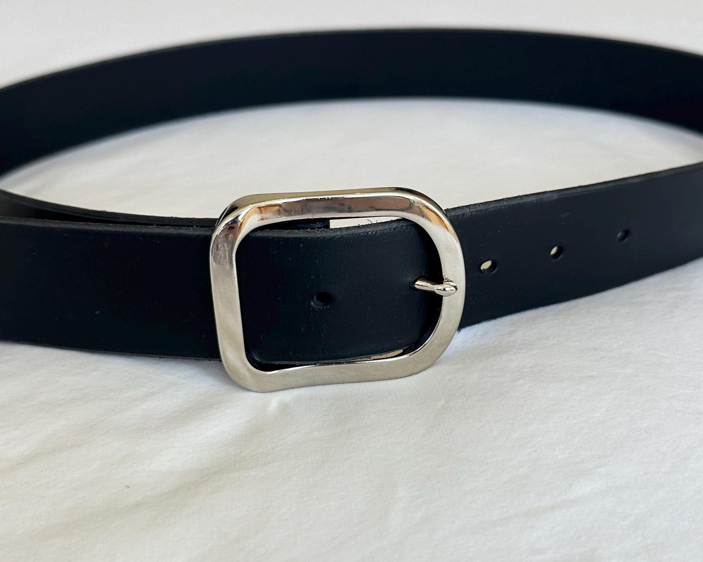 Black belt with a silver buckle on a white background