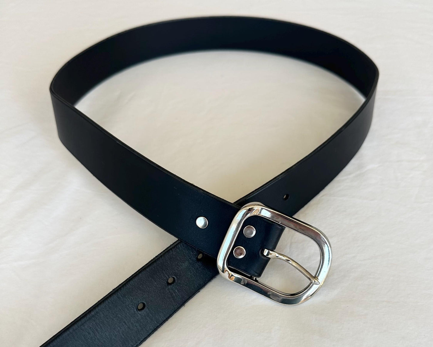 Black belt with a silver buckle on a white background