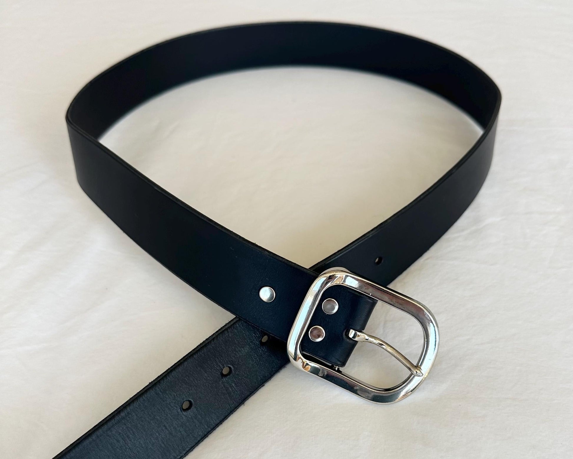 Black belt with a silver buckle on a white background