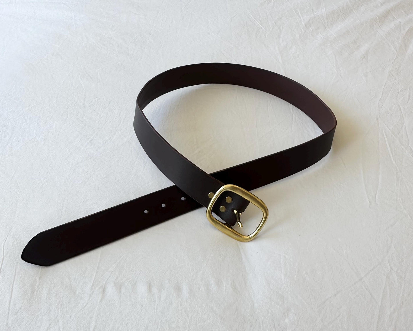 Black belt with a gold buckle on a white background