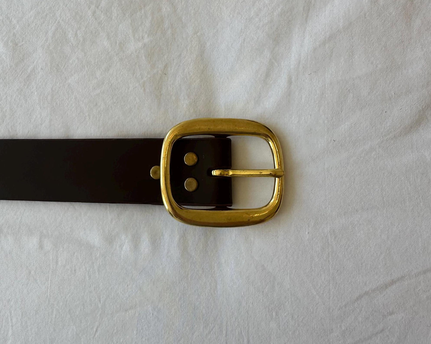 Black belt with a gold buckle on a white background