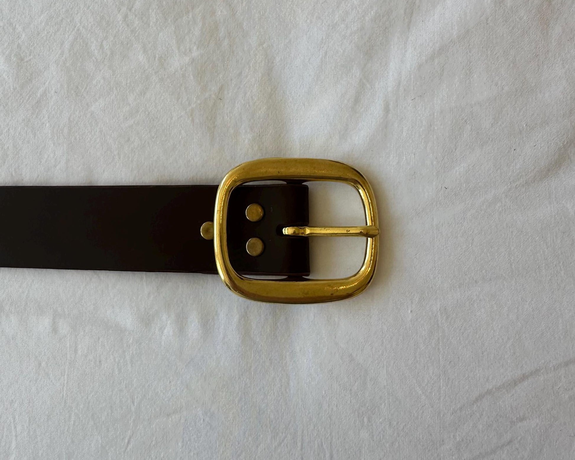 Black belt with a gold buckle on a white background